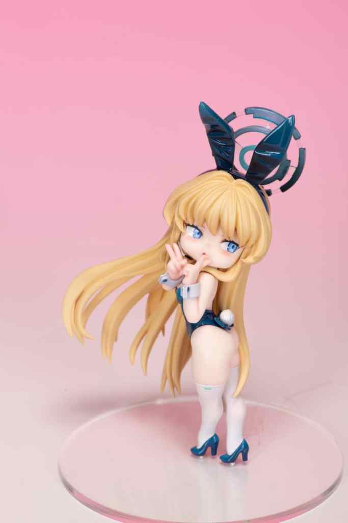 SDブルーアーカイブのキャラクター、トキがバニーガールのコスチュームでポーズをとっているフィギュア。背景は淡いピンクで、フィギュアは透明な台座に設置されています。