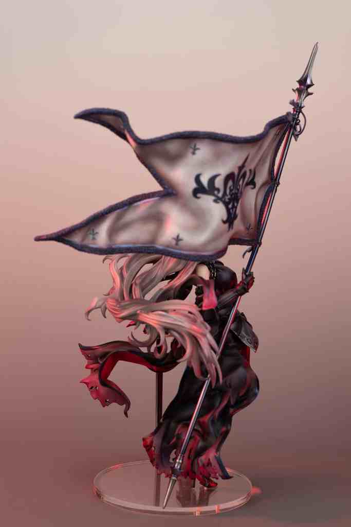 A detailed figure of a character holding a flag decorated with a design, featuring long flowing hair and a dark outfit with a dramatic pose.