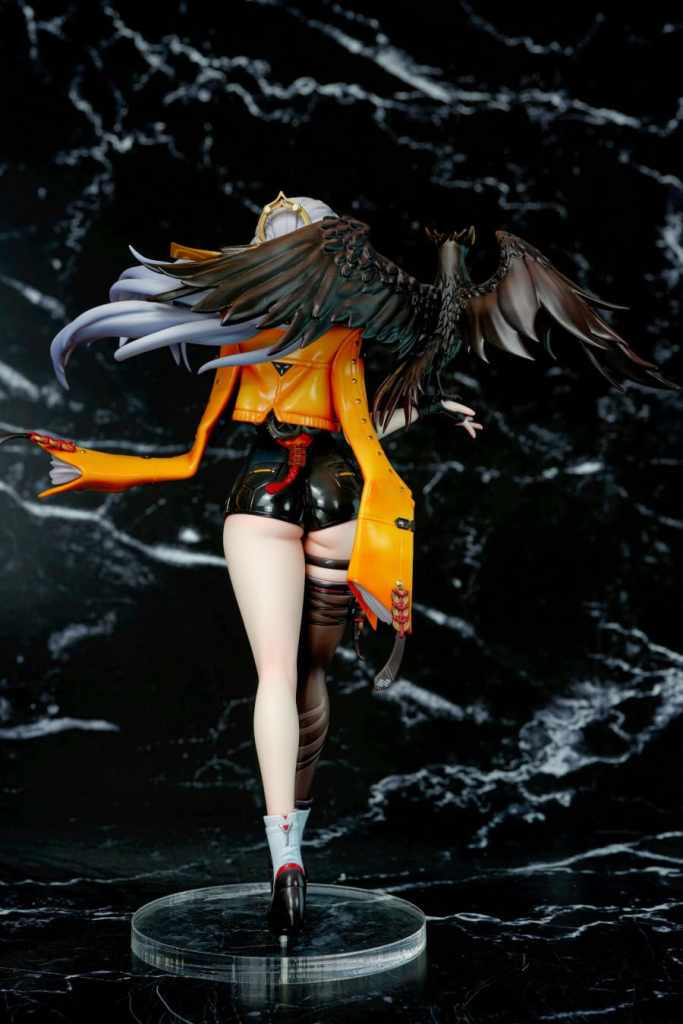 A detailed figure of a character with long hair and a black and orange outfit, featuring an intricate design and a pair of large wings on their back.