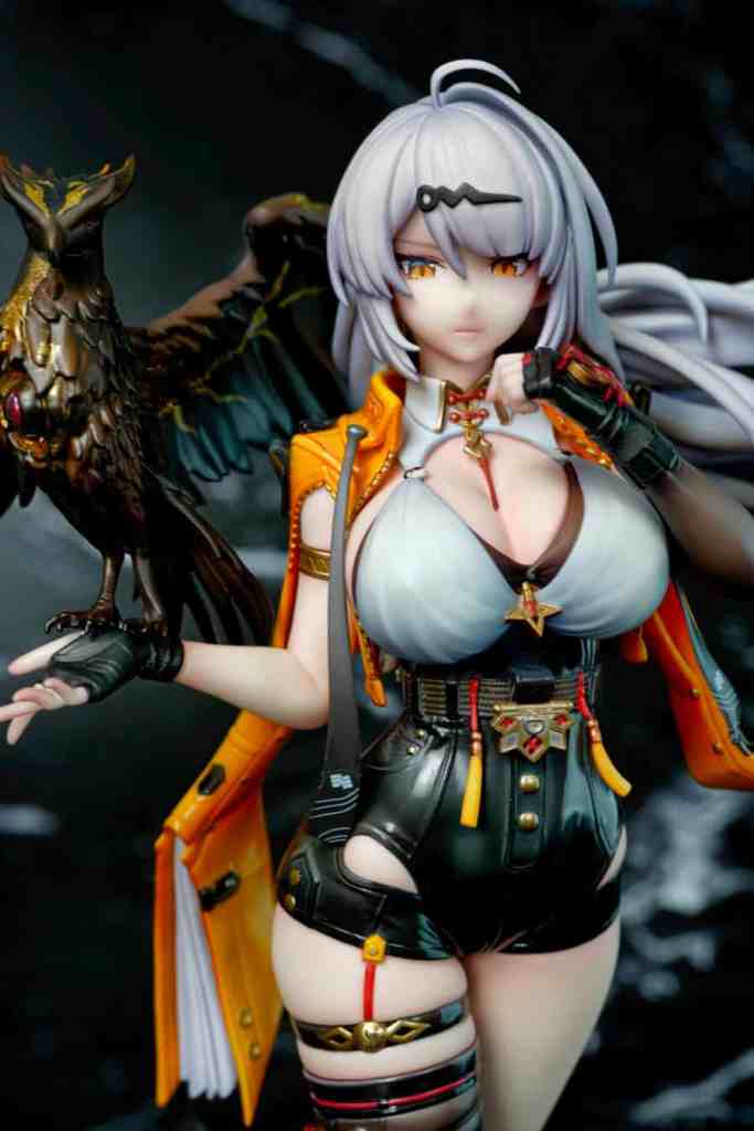 A detailed figurine of a character with silver hair and orange eyes, dressed in a black and orange outfit, posing confidently with a raven on her shoulder.