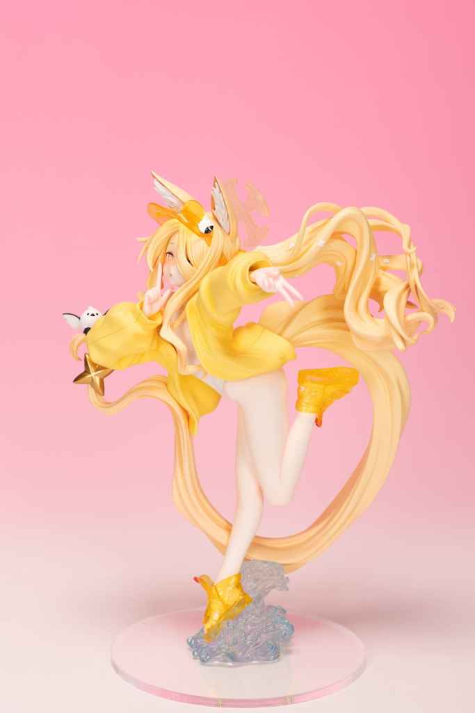 A vibrant figure of a character with long blonde hair, wearing a yellow oversized hoodie and playful footwear, adorned with animal ears and a tail, striking a dynamic pose against a pink background.