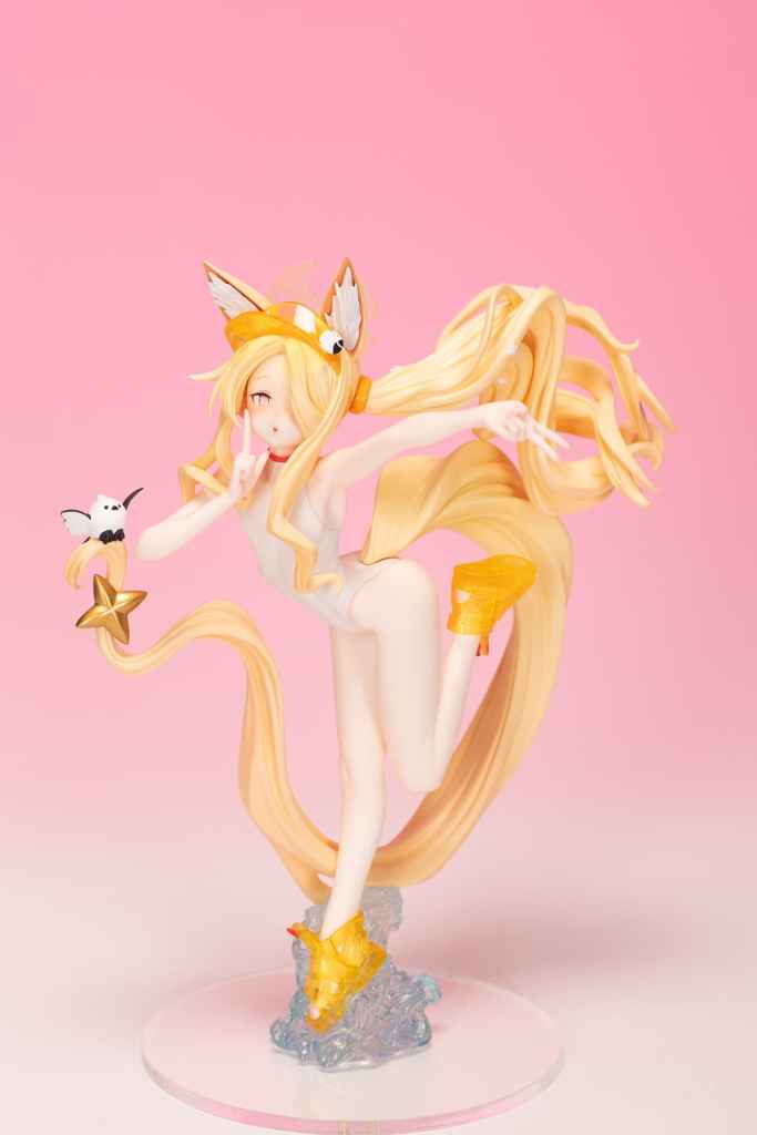 A vibrant anime-style figure of a girl with long blonde hair and fox ears, wearing a white outfit and yellow shoes. She poses playfully with one leg raised, surrounded by a colorful pink background.