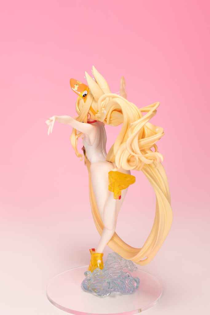 A detailed figurine of a character with long, flowing blonde hair, wearing a swimsuit and yellow accessories, posed gracefully against a pink background.