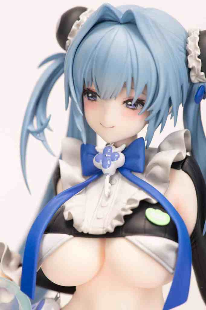 Close-up of a detailed anime figurine featuring a character with blue hair and a maid costume, complete with bows and ribbons.